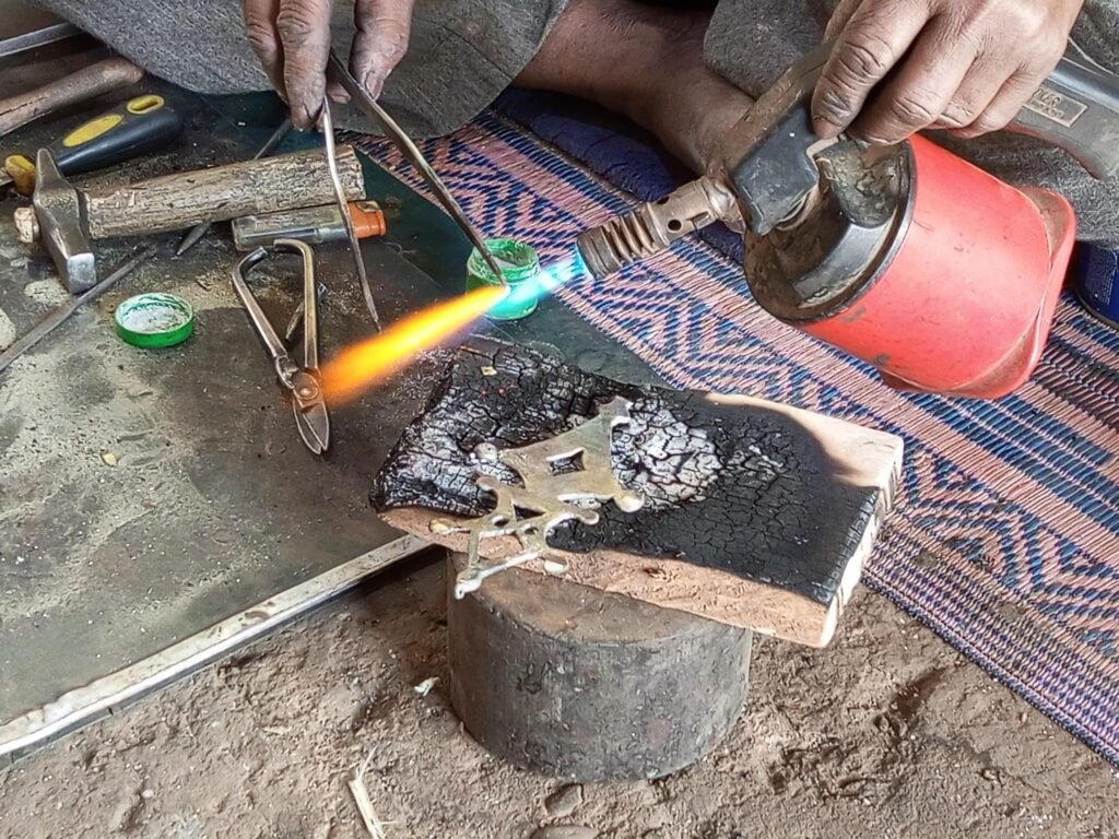 Un artisan façonne une croix d’Agadez à la main dans son atelier